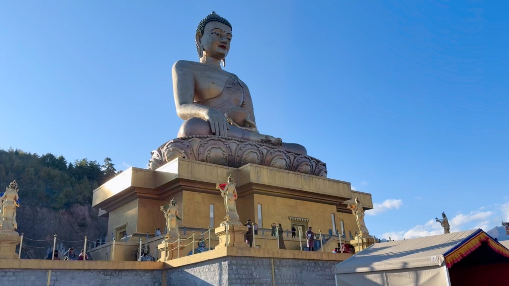 Die massive Frontalansicht des Shakyamuni Buddha (Buddha Dordenma) im Kuensel Phodrang Nature Park unter strahlend blauem Himmel.