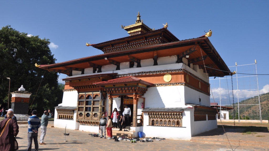 The Chimi Lhakhang (Temple of the "Divine Madman") in the sunlight; the distinctive small black stupa is visible on the left side.