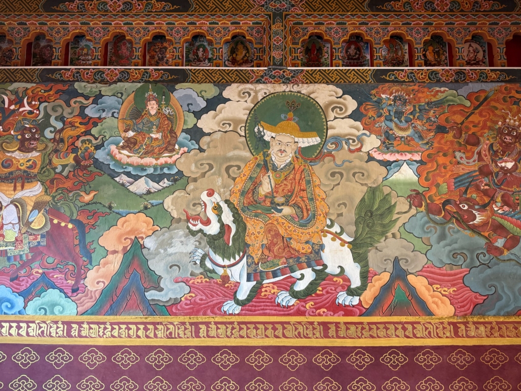 Intricate, colorful Buddhist wall mural in the entrance area of Gangtey Goenpa depicting a deity riding a white snow lion.